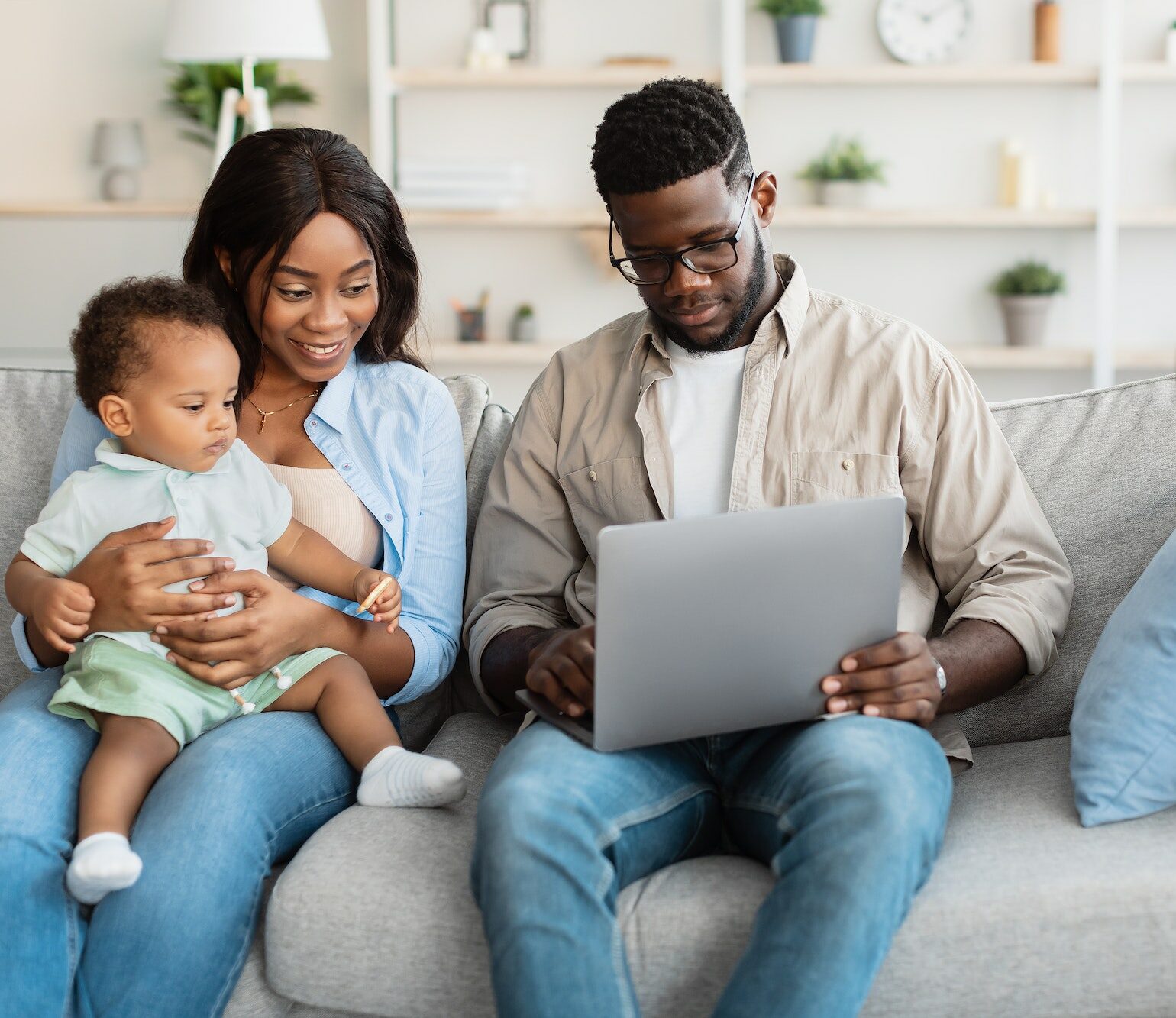 African american family using computer with baby at home